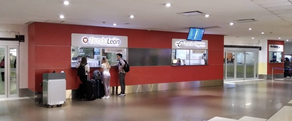 guichets des entreprises Tienda leon et Transfer express dans le hall des arrivées internationales de l'aéroport d'Ezeiza en Argentine