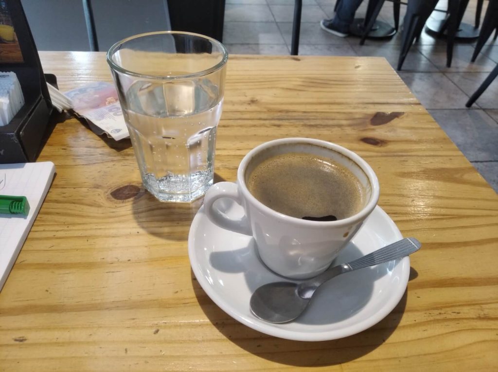 Tasse de café accompagnée d'un verre d'eau gazeuse dans un bar en Argentine