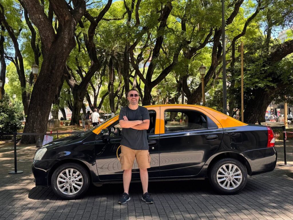 Enzo, guide francophone à Buenos Aires, devant son taxi