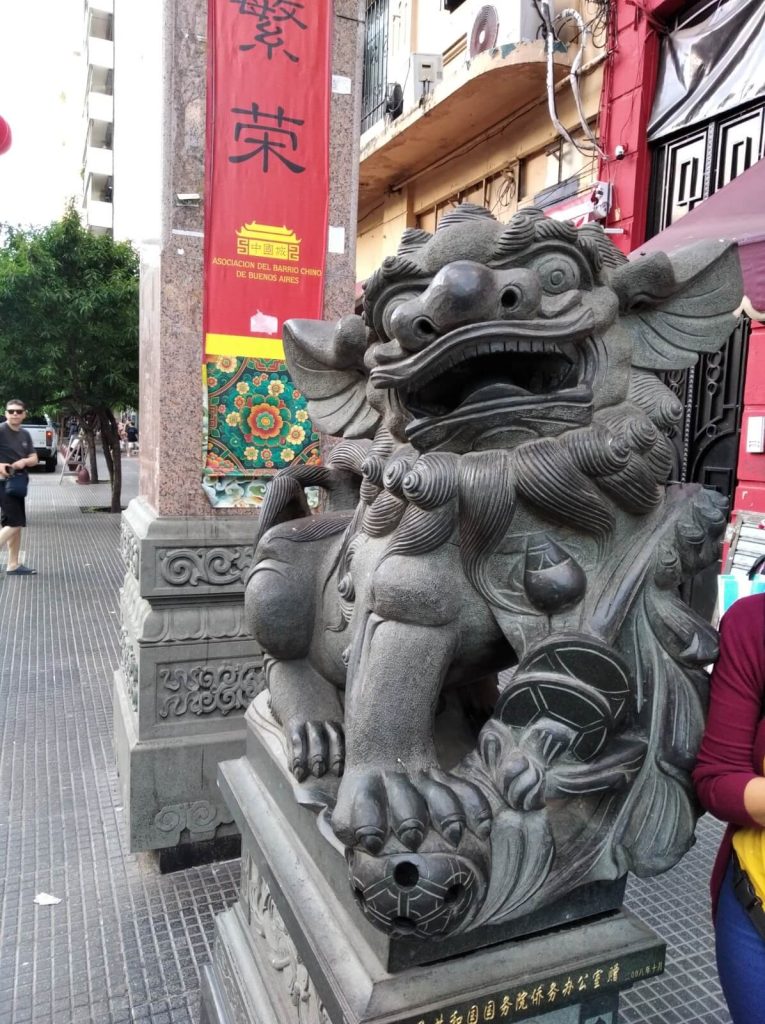 Lion en pierre au pied d'une colonne de l'arche chinoise à l'entrée du Barrio chino de Buenos Aires